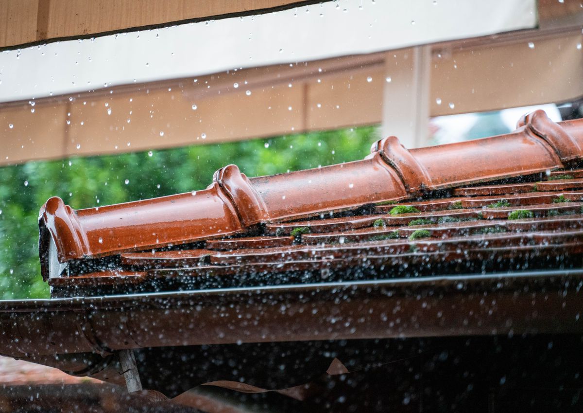 Rain running from a tiled roof into a gutter