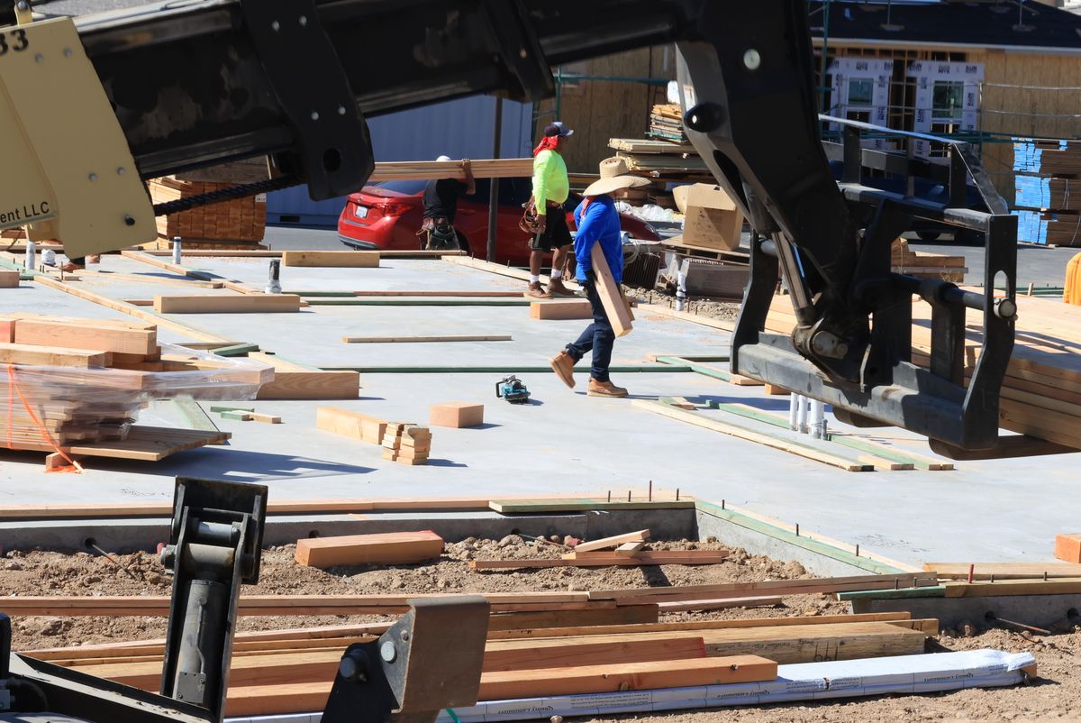 Timber and equipment staged around a residential construction site