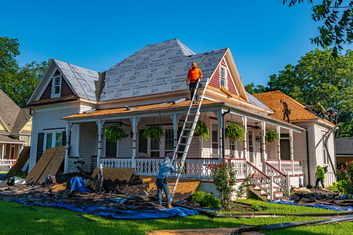 Roof replacement in progress on a house with a front porch